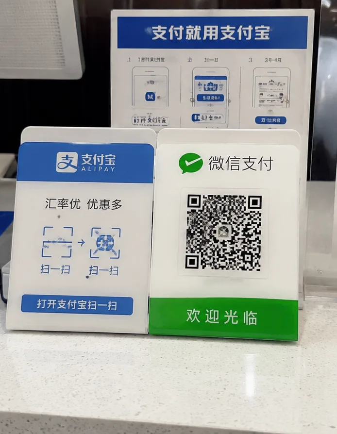 Papan kode QR Alipay dan WeChat Pay di meja kasir sebuah toko di China