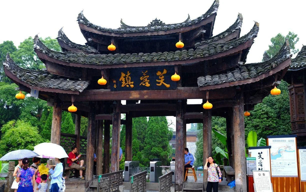Gerbang masuk Furong Ancient Town dengan pintu putar tiket di bawah gapura kayu