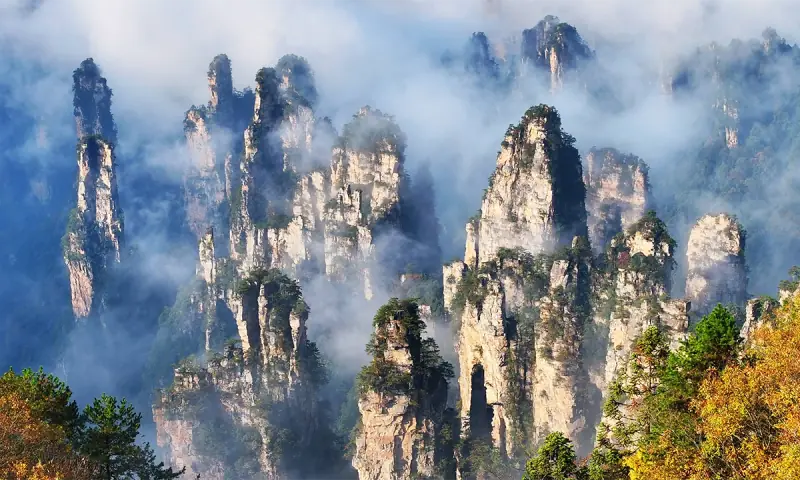 Awan mengalir di antara puncak batu pasir Zhangjiajie