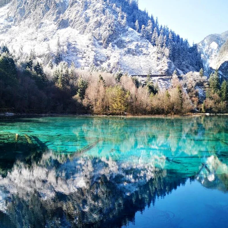 Danau berwarna pirus dan lereng berhutan di Taman Nasional Jiuzhaigou