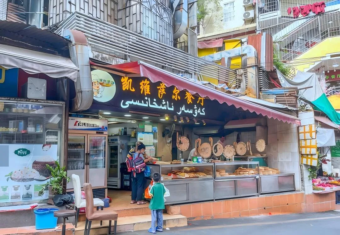 Restoran halal Uighur dengan naan segar dan aneka roti yang dipajang di konter menghadap jalan