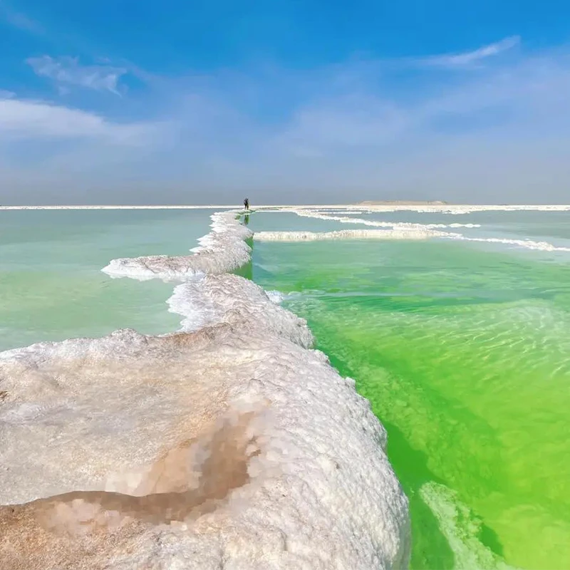 Hamparan garam putih dan air biru kehijauan di kawasan wisata Danau Garam Xinjiang dekat Urumqi