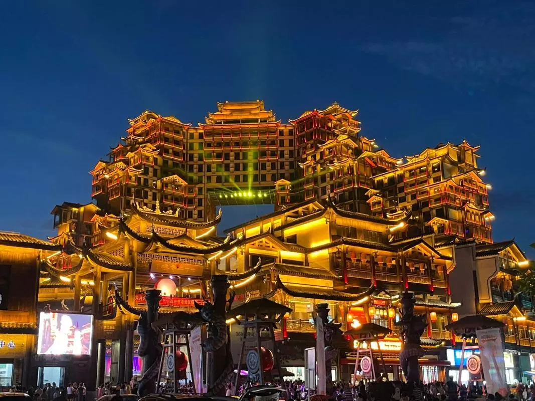 Suasana jalan malam 72 Wonder Tower Zhangjiajie dengan pengunjung dan bangunan yang diterangi