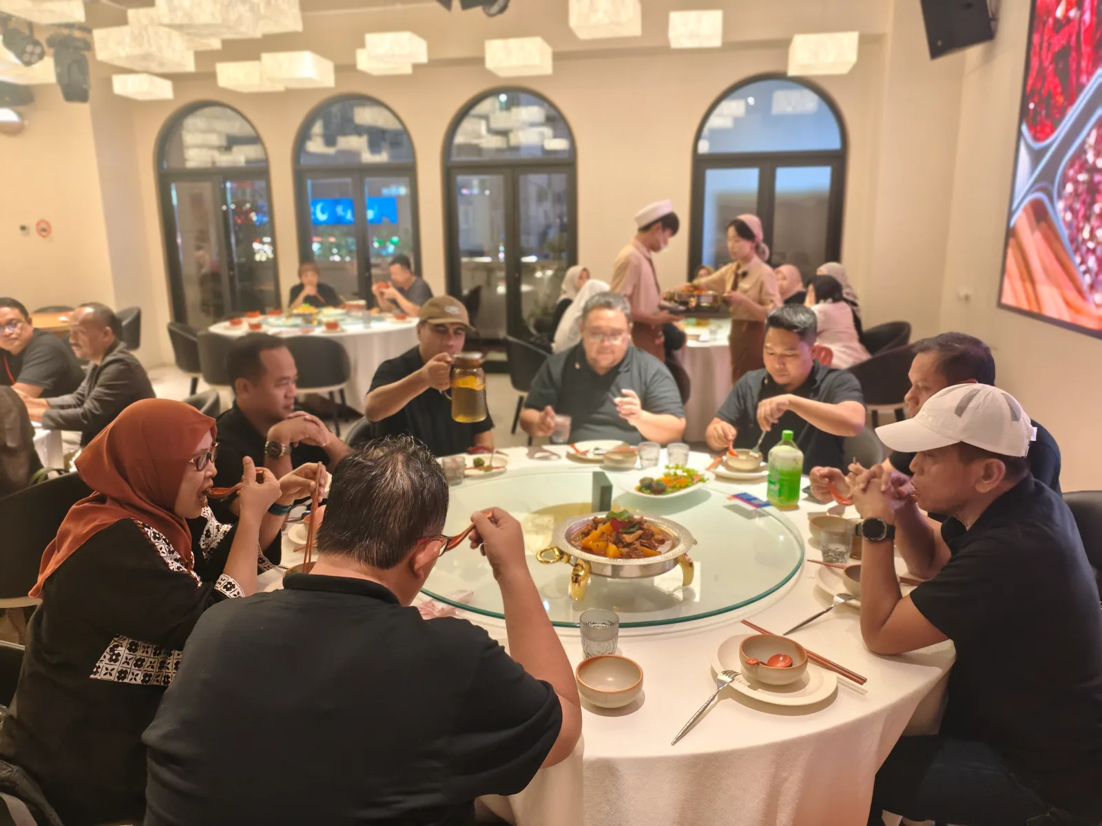 Rombongan wisatawan Muslim menyantap makan malam bersama di meja putar sebuah restoran halal di China